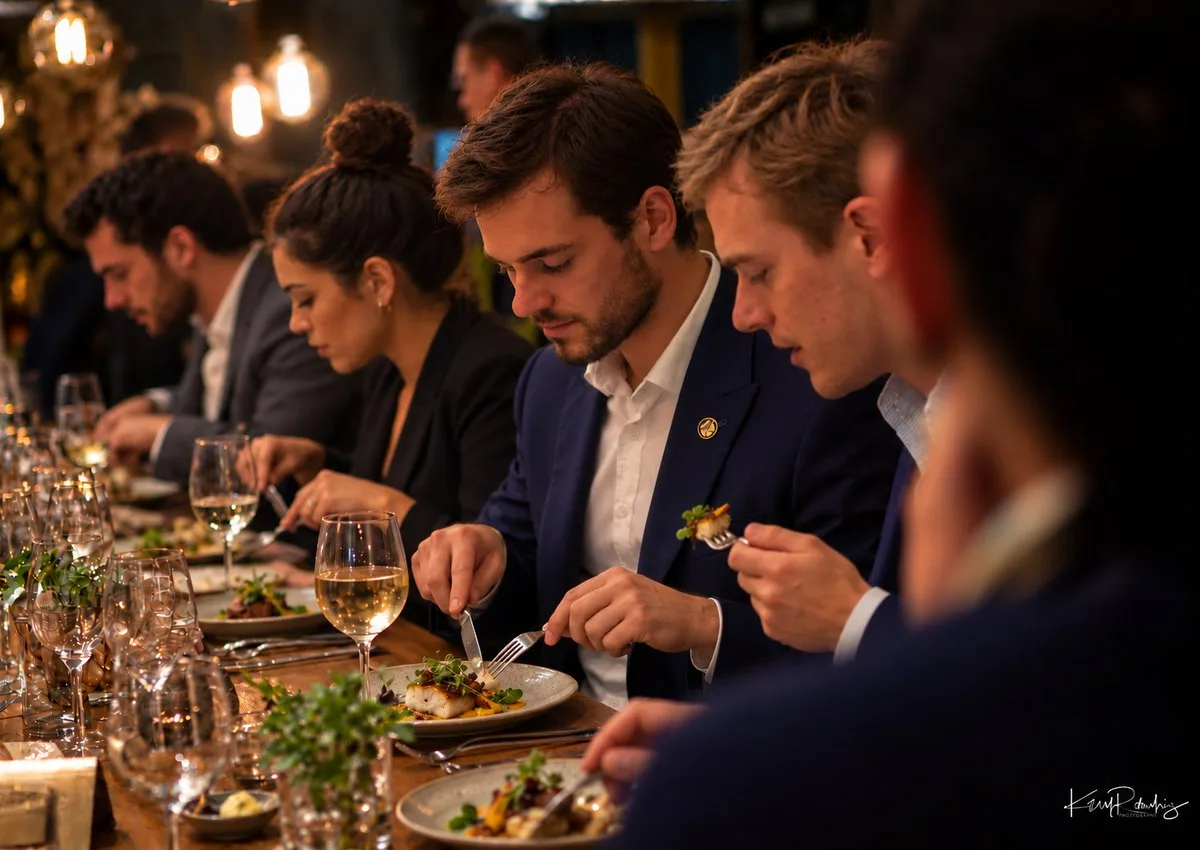 Gasten genieten van een groepsdiner aan lange tafel bij Nomad aan het IJ