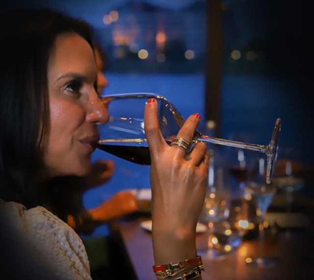 Gast met een glas wijn bij Nomad aan het IJ